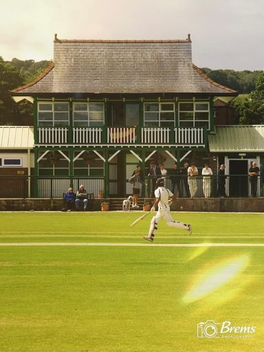 A man running on the cricket field playing cricket