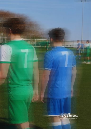 The back of two football players at a football match