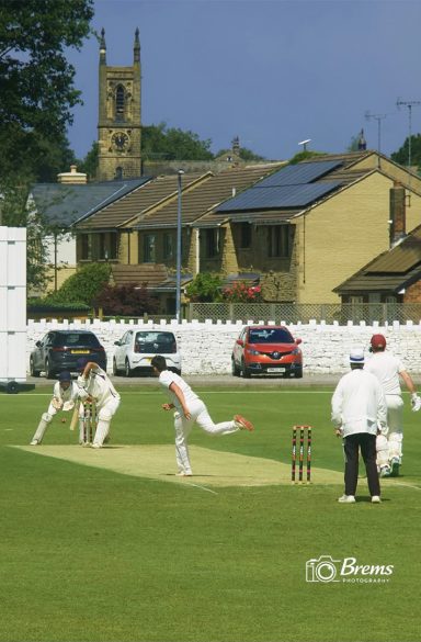 People playing on the cricket field at a cricket match